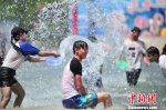 近日，持续的晴热天气让云南大部分地区气温急剧飙升。图为游客在昆明参加泼水节活动。　刘冉阳 摄 - 云南频道