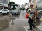 环城北路与北京路交叉路口，一名民警背着一位老人蹚水发过马路 - 云南频道