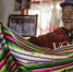 独龙族妇女李文仕在家里展示她亲手织的独龙毯。新华社记者 江文耀 摄 - 云南频道