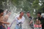 图为参加者在泼水体验区接受当地傣族泼水祝福 陶平 摄 - 云南频道